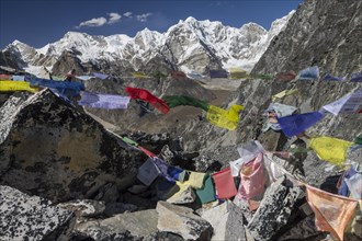 Kongma La with Buddhist prayer flags, view towards the West. The eight-thousander Cho Oyu, the sixth-highest mountain in the world, is on the left, under the cloud here. Tenzing Peak is also visible, ...