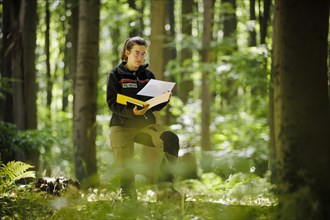 An employee of the Northwest German Forest Research Institute stands on an experimental plot in a deciduous forest in Lower Saxony. Here, research is being conducted into how the forest can be prepare...