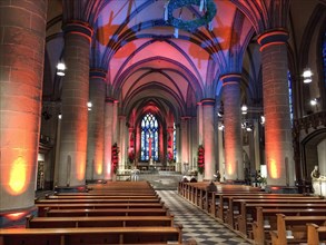 Festively lit interior central nave of Essen Cathedral Muenster former collegiate church cathedral church bishop's seat Ruhrbistum diocese Essen, Advent wreath hung on top, Essen, North Rhine-Westphal...