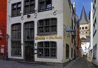 Salzgasse with the historic brewery Suenner im Walfisch and view to the church Gross St Martin, Old Town, Cologne, Rhineland, North Rhine-Westphalia, Germany, Europe