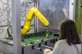 Girl playing table football against a robot. The trade show Didacta is Europes largest education trade fair, Stuttgart, Baden-Wuerttemberg, Germany, Europe