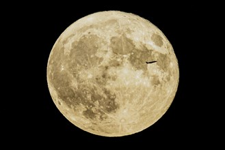 A plane looms in front of the so-called strawberry moon looms as it rises in Berlin, 14.06.2022., Berlin, Germany, Europe