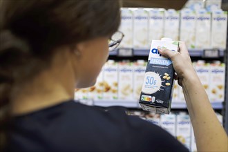 Younger woman buys a protein drink in a supermarket. Radevormwald, Germany, Europe