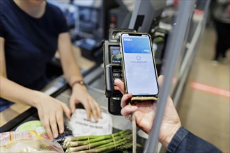 Payment by mobile phone in the supermarket. Radevormwald, Germany, Europe