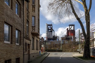 Residential area Duisburg-Bruckhausen, behind industrial scenery with blast furnace of Thyssenkrupp Steel Europe AG, Duisburg, North Rhine-Westphalia, Germany, Europe