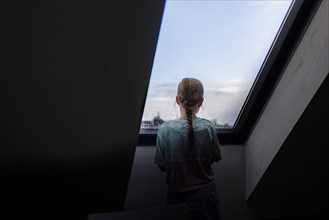 Girl looking out of the window, Bonn, Germany, Europe