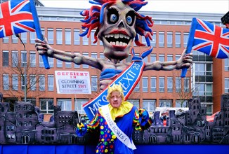 Theme float by Jaques Tilly: Carnivalist with Boris Johnson mask in front of the Brexit float, Rosenmontagszug in Duesseldorf, North Rhine-Westphalia