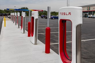 Elkhart, Indiana, Charging stations for Tesla electric vehicles next to a Sunoco gas station on the Indiana Toll Road