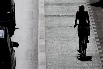 A woman rides her bike in a bike lane on Schlossstrasse in Berl, Berlin, Germany, Europe