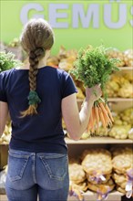 Woman buying carrots at the supermarket, Radevormwald, Germany, Europe