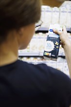 Younger woman buys a protein drink in a supermarket. Radevormwald, Germany, Europe