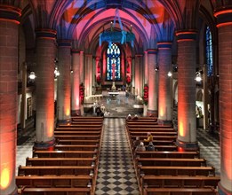View from elevated position on festively lit interior central nave of Essen Cathedral Muenster former collegiate church cathedral church bishop's seat Ruhrbistum diocese Essen, Advent wreath hanging f...