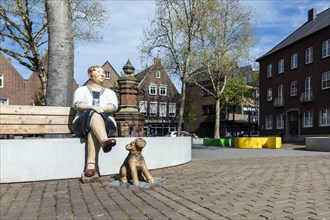 Cheering Pan with Dog Everyday Man by Christel Lechner, sculpture on a bench at the market, Rees, North Rhine-Westphalia, North Rhine-Westphalia, Germany, Europe