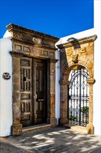 Old wooden doors with pebble mosaics on the floor, winding streets with white houses, Lindos, Rhodes, Greece, Europe
