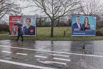 A woman with an umbrella stands out in front of apartment blocks and election posters in the district of Marzahn, photographed in Berlin, 01.02.2023., Berlin, Germany, Europe