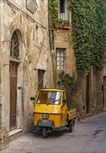 Three-wheeler in the streets of Pitigliano old town, Tuscany, Italy, Europe