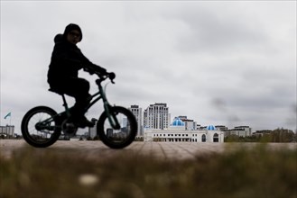 A child on a bicycle stands out in Astana, Astana, Kazakhstan, Asia