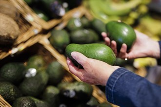 Older woman buys avocados at the supermarket. Radevormwald, Germany, Europe