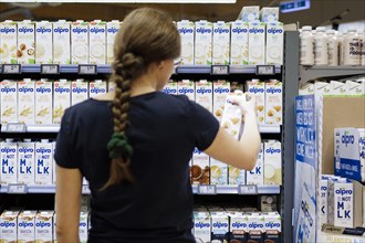 Young woman buys an Alpro product in a supermarket. Radevormwald, Germany, Europe