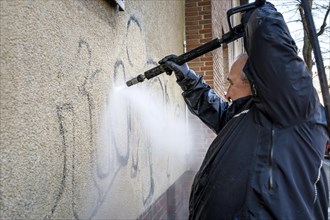 Removal of graffiti from house wall, high-pressure cleaner, residential area, Duesseldorf, North Rhine-Westphalia, Germany, Europe