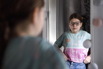 Ten year old girl betrays herself in the mirror, Bonn, Germany, Europe