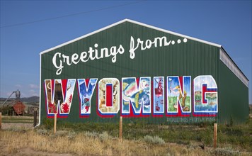 Encampment, Wyoming, A barn painted as a postcard-style greeting from Wyoming