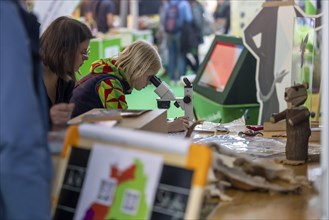 A child looks through a microscope. The trade fair Didacta is Europes largest education trade fair, target groups are teachers and trainers at kindergartens, schools and universities. Stuttgart, Baden...