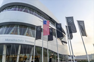 The American flag flies in front of the Mercedes Museum, Mercedes-Benz Group AG, Stuttgart, Baden-Wuerttemberg, Germany, Europe