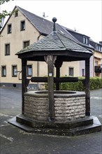 Fountain on Graf-Mirbach-Platz in front of the Catholic parish church of St. Martin, Hillesheim, Rhineland-Palatinate, Germany, Europe
