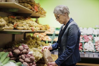 Woman buying potatoes in a supermarket in Radevormwald, 08.06.2022. Radevormwald, Germany, Europe