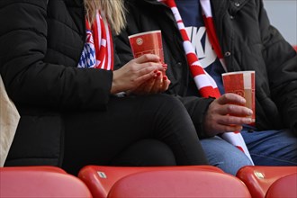 Spectators with FC Bayern Munich FCB scarves and drinking cups, woman, man, detail, logo, Allianz Arena, Munich, Bavaria, Germany, Europe