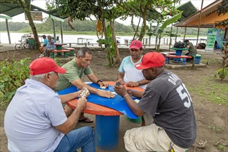 Tortuguero, Costa Rica, Men play dominoes in a small village on the Caribbean coast next to Tortuguero National Park, Central America