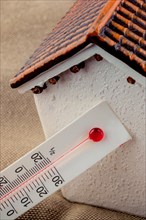Thermometer measuring temperature by a little model house