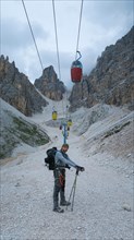 Tourist from the inventory trail in the gully with the gondola lift to Forcella Staunies