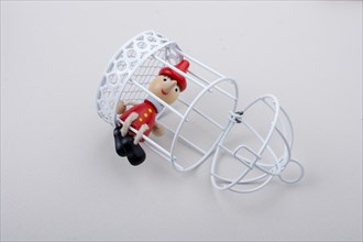 Metal cage and Little puppet pinocchio made of wood