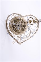 Pocket watch in a heart shaped metal wire cage in hand