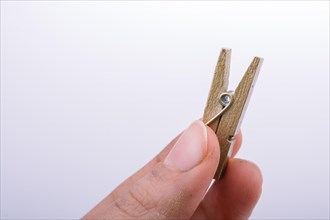 Hand holding a small wooden clothespin in hand
