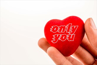 Heart shape object in hand with only you inscription