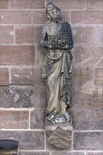 Sculpture of a saint with a dove grille at the Lorenzkirche
