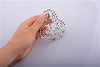 Heart shaped silver color metal wire cage in hand