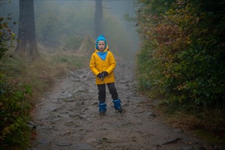 The child is standing on the mountain trail in the raincoat. Polish mountains
