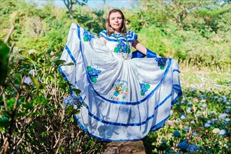 Nicaraguan woman in traditional folk costume in a field of Milflores
