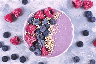 Top view of healthy yogurt and fruit smoothie bowl decorated with raspberry