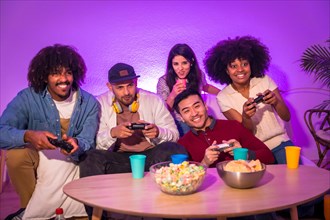 Adult party. Attractive young men sitting on the sofa playing video games. Expressing joy while holding the joystick and looking at the monitor