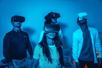 Group of young people with vr glasses in a virtual reality game in a blue light