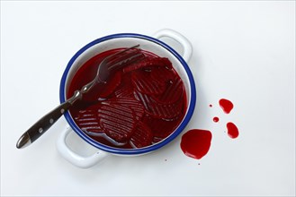 Sliced pickled beetroot with peel and fork