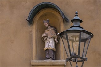 Sculpture of St. Nepomuk in a niche on a residential house