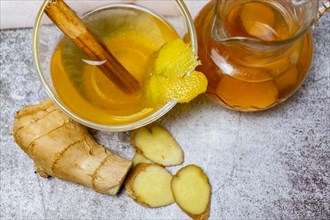 Top view of jar of fresh ginger tea with lemon and cinnamon
