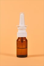 Brown glass nasal spray bottle on yellow background
