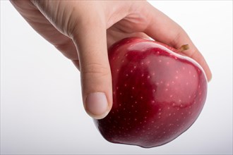 Hand holding a beautiful red apple on a white background
